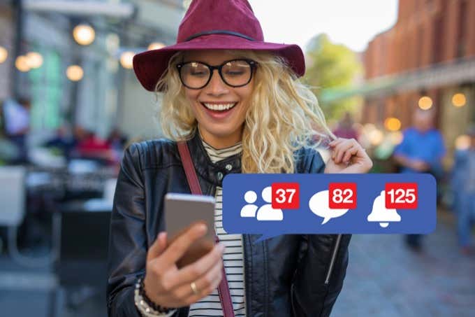 Woman excited about getting attention on social media - Online Tech Tips Woman looking at facebook on smartphone - Woman excited about getting attention on social media